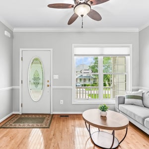 Bright and inviting living space featuring large windows, natural light, and a comfortable seating area.