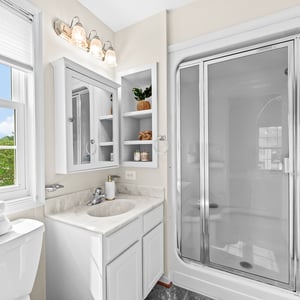 Bright and inviting bathroom featuring modern fixtures, ample storage, and natural light from large windows.