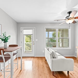 Bright and airy living space featuring hardwood floors, a cozy seating area, and a view of nature.