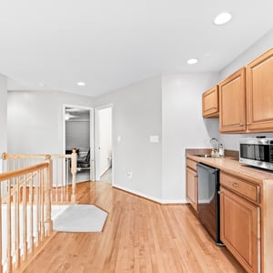Modern wet bar with hardwood floors, featuring modern appliances and ample natural light throughout.
