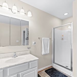 Bright and functional bathroom featuring modern fixtures, a spacious shower, and ample storage options.