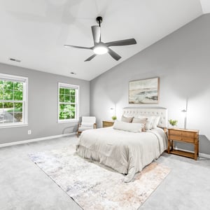Spacious bedroom featuring high ceilings, abundant natural light, and modern furnishings, ideal for relaxation and comfort.