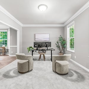 Bright and airy office space featuring dual seating and large windows that invite natural light.