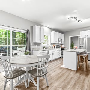 Bright and airy kitchen featuring modern appliances, a spacious layout, and access to outdoor views.