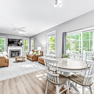 Bright and inviting living space featuring ample natural light, a cozy fireplace, and modern design.