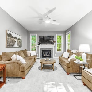 Bright and inviting living room featuring a cozy fireplace, large windows, and comfortable seating options.