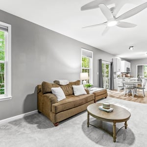 Spacious living area with natural light, open layout, and modern kitchen perfect for gatherings and relaxation.