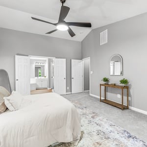 Spacious master bedroom with vaulted ceiling, abundant natural light, and a convenient en-suite bathroom.