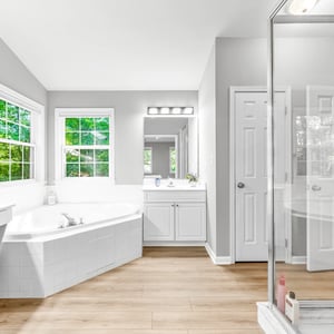 Bright and airy bathroom featuring a spacious layout, soaking tub, and large windows for natural light.