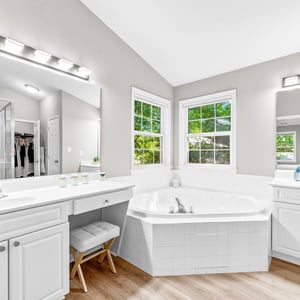 Spacious bathroom with dual vanities, a luxurious soaking tub, and abundant natural light.