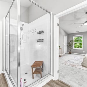 Bright and spacious master suite features an inviting bathroom with a glass shower and ample closet space.