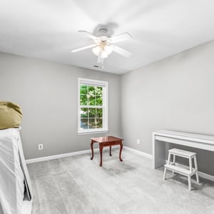 Bright and inviting bedroom featuring ample natural light and a functional layout perfect for personal touches.