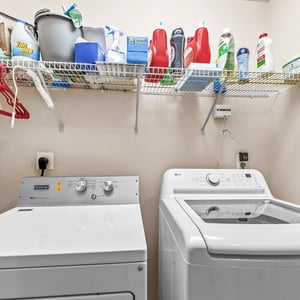 Functional laundry room featuring modern appliances and ample storage for all your cleaning supplies.