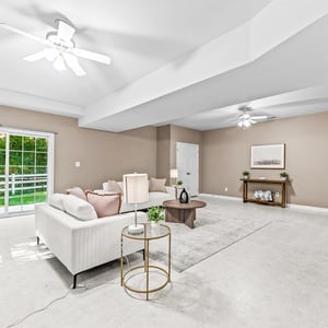 Spacious living area featuring natural light, easy access to outdoor space, and modern ceiling fans.