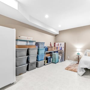 Spacious basement bonus room with ample storage options, featuring a cozy sleeping area and practical organization solutions.