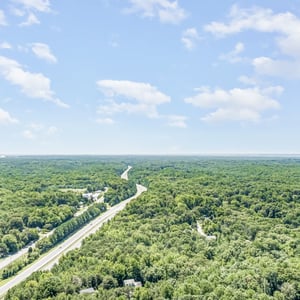 Expansive wooded lot offers ample space, surrounded by natural beauty and easy highway access.