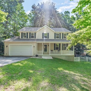 Discover this spacious home set on a lush, wooded lot, featuring a welcoming front porch and ample parking.