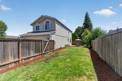 Spacious backyard features well-maintained landscaping and a cozy seating area, perfect for outdoor gatherings.