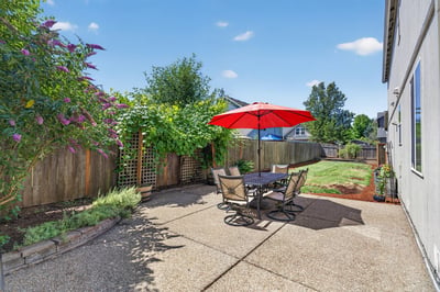 This inviting outdoor space features a patio with a vibrant umbrella, perfect for relaxation and gatherings.