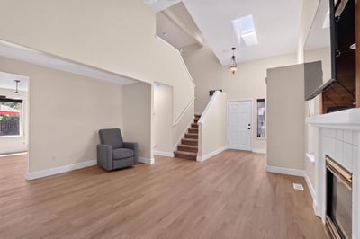 Spacious living area with natural light, modern finishes, and an inviting staircase leading to upper levels.