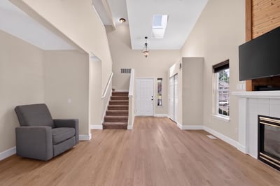 Bright and open living space featuring high ceilings, a cozy fireplace, and abundant natural light.