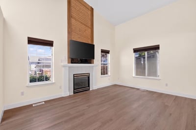 Spacious living area featuring large windows, modern fireplace, and high ceilings perfect for entertaining or relaxing.