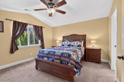 Spacious bedroom featuring vaulted ceilings, ample natural light, and cozy furnishings for ultimate relaxation.