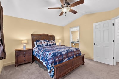 Cozy bedroom featuring a comfortable bed, warm lighting, and a spacious layout with an inviting atmosphere.