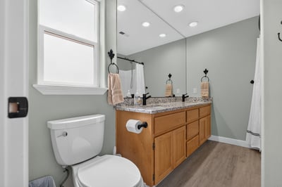 Modern bathroom featuring dual sinks, granite countertops, and ample natural light, perfect for daily routines.