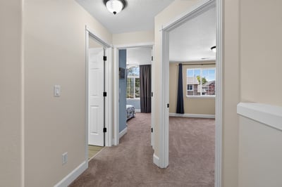 Bright and inviting hallway leads to spacious bedrooms, offering comfortable living in a warm atmosphere.
