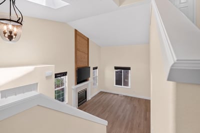 Bright, open living space featuring vaulted ceilings, modern fireplace, and ample natural light throughout.