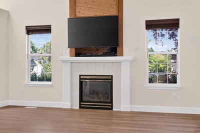 Bright living room featuring a modern fireplace, large windows, and a mounted TV for entertainment convenience.