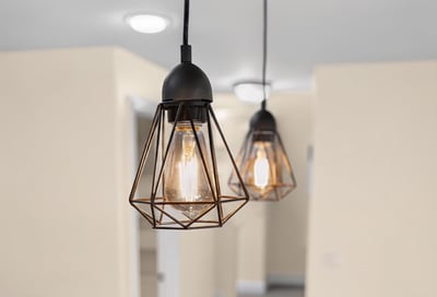 Modern pendant lights illuminate a spacious, inviting interior, perfect for creating a warm and vibrant atmosphere.