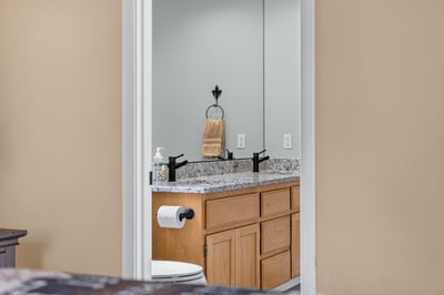 Modern bathroom featuring a dual-sink vanity with granite countertops and sleek black fixtures for a fresh look.