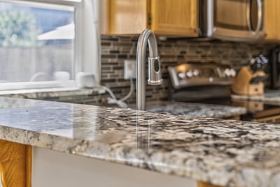 This modern kitchen features a spacious granite countertop, perfect for meal preparation and entertaining.
