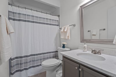 Updated primary bathroom with walk-in shower, granite countertop and new mirror