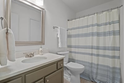 Updated hall bath with painted vanity, quartz countertop, new light fixture and new mirror
