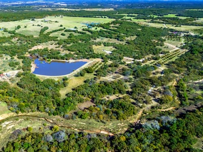 PROPERTY AERIAL...Exceptional 284 Acre Ranch With A Log Cabin, Lake, Ponds, Creeks, Pecan Orchard, Hay Meadow, Woods, And Outbuildings!
