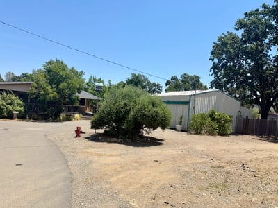 HOUSE WITH FIRE HYDRANT AND SHOP TO THE RIGHT.