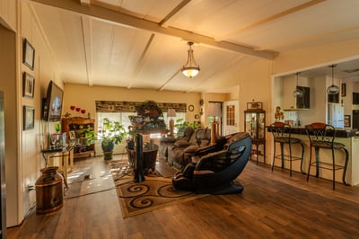 LIVING ROOM WITH FRONT DOOR ENTRANCE IN THE BACKGROUND AND BEAUTIFUL CUSTOM BREAKFAST BAR TO THE RIGHT.