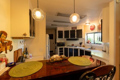 KITCHEN WITH BREAKFAST BAR IN FORGROUND.