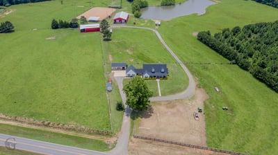 Spacious countryside property featuring a cozy home, expansive fields, and a tranquil pond, ideal for outdoor enthusiasts.