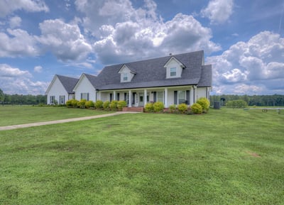 This countryside home features ample yard space, stunning views, and a welcoming front porch.