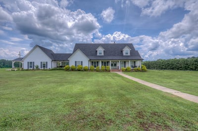 Spacious countryside home with expansive lawns, covered parking, and scenic views, ideal for relaxation and family gatherings.
