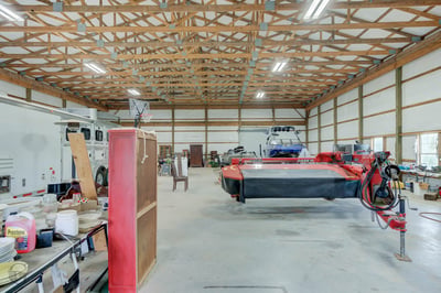 Spacious multi-use barn featuring high ceilings, abundant natural light, and ample room for equipment and storage.