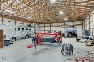 Spacious barn with high ceilings, ideal for storing vehicles, equipment, or pursuing hobbies in comfort.