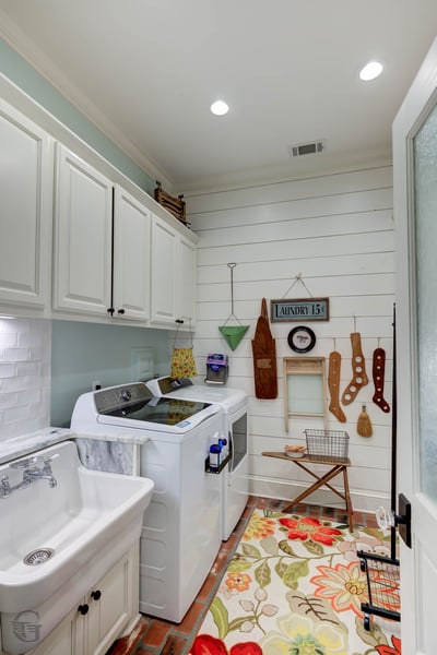 Bright and functional laundry room featuring modern appliances, ample storage, and unique decorative accents.