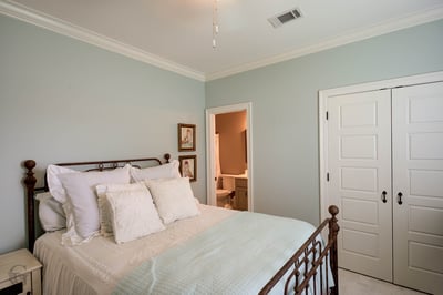 Cozy bedroom with soft hues, featuring a comfortable bed and access to a private bathroom.