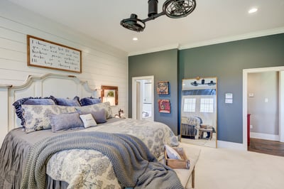 Spacious bedroom featuring a cozy bed, unique decor, and ample natural light for relaxation.