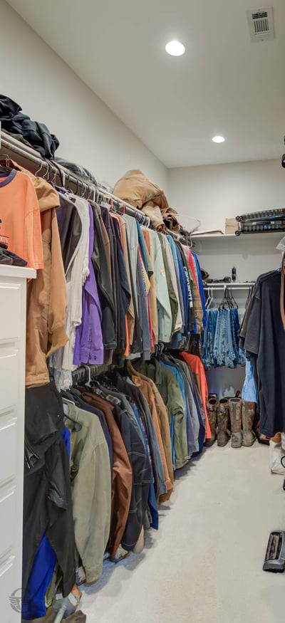 Spacious walk-in closet organized with ample shelving, perfect for storing a diverse wardrobe and accessories.